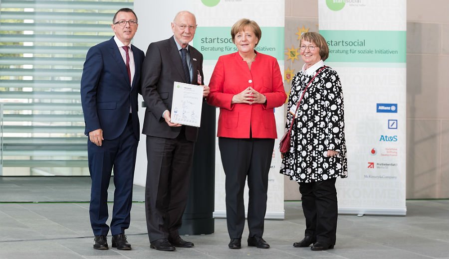 Angela Merkel mit start-social-Chef Dieter Düsedau und den MiKibU-Vertretern Christiane Müller und Henry Stewen