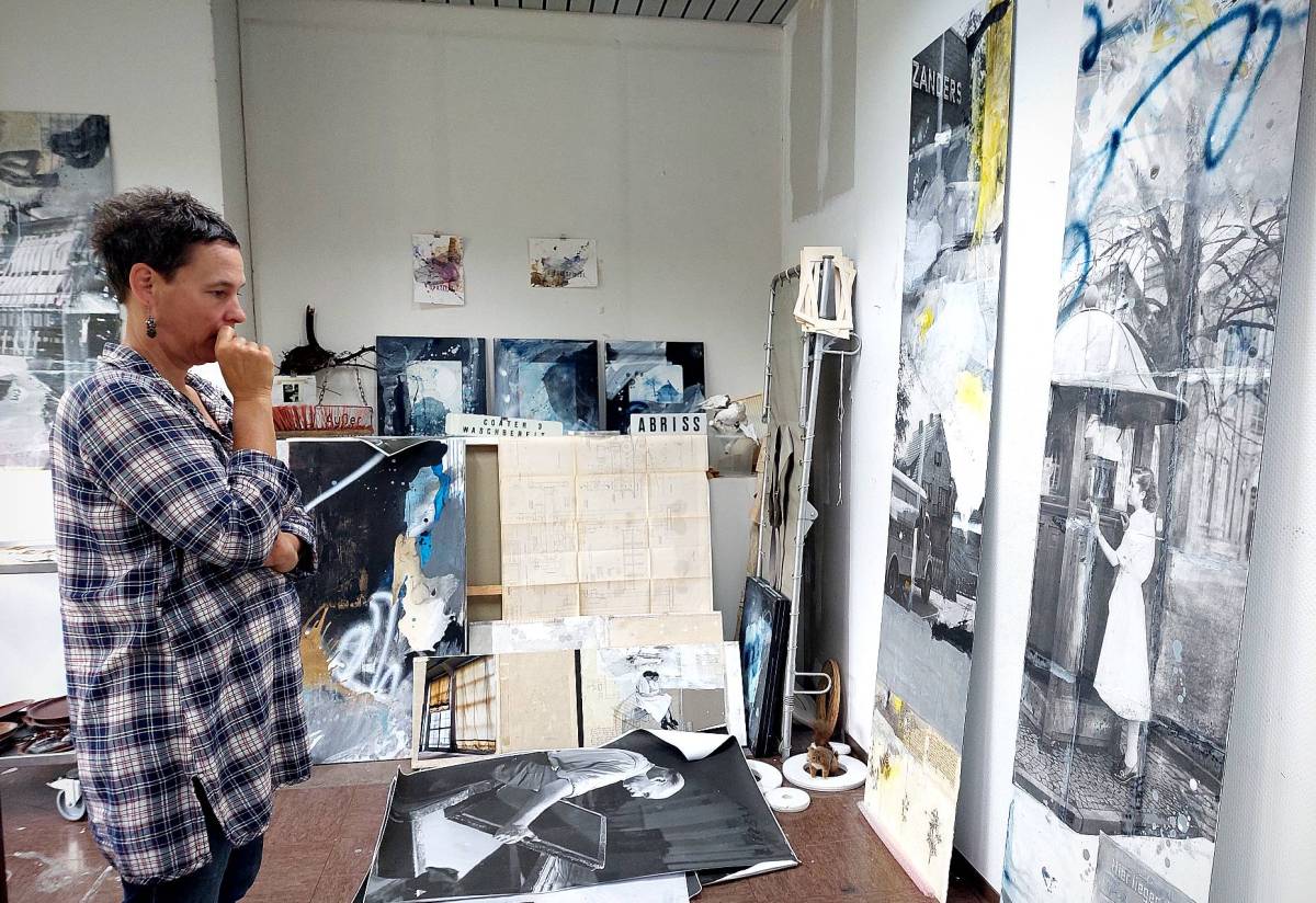Die Künstlerin Iris Stephan betrachtet in ihrem Atelier auf dem Zanders-Gelände Kunstwerke, an denen sie gerade arbeitet